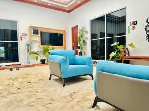 uma sala de estar com duas cadeiras e um sofá em Pelican Beach Maafushi em Maafushi