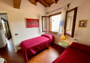 Habitación con cama roja y ventana en A.I.R. Residence La Misuaglia, en Isola Rossa