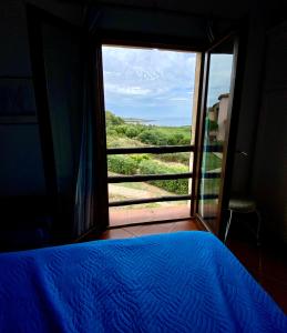 a bedroom with a bed and a window with a view at A.I.R. Residence La Misuaglia in Isola Rossa