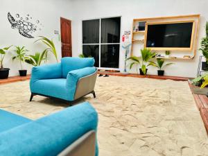 uma sala de estar com uma cadeira azul e uma televisão em Pelican Beach Maafushi em Maafushi