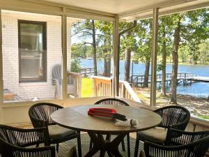 a table and chairs on a porch with a view of the water at Blue Heron Bungalow on Lake Murray, SC in Chapin