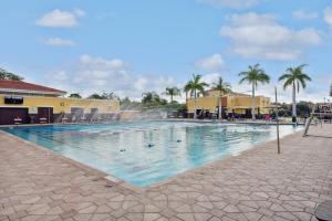 a swimming pool at a resort with palm trees at 2 bedroom Tampa Condo at Private Golf Course condo in Tampa