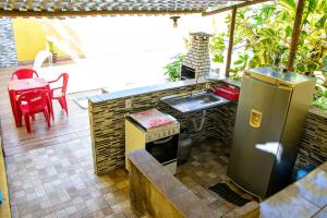 - une cuisine extérieure avec une cuisinière et une table dans l'établissement Casa aconchegante com piscina em Camacari BA, à Camassari