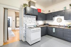 a kitchen with black cabinets and white appliances at Quaint Home with Yard about 4 Mi to Downtown Louisville! in Louisville