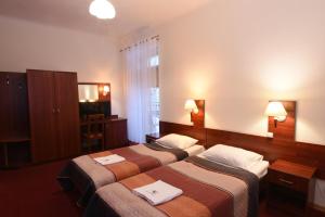 a hotel room with two beds with towels on them at Pegaz in Karpacz