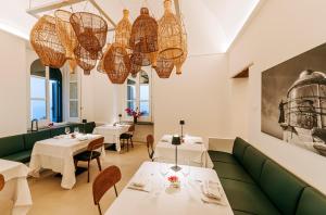 a restaurant with tables and chairs and chandeliers at Faro Punta Imperatore in Ischia