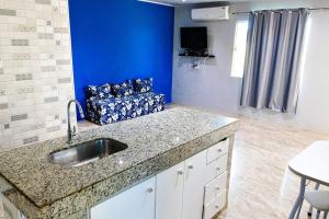 eine Küche mit einem Waschbecken und einem Sofa in einem Zimmer in der Unterkunft Casa aconchegante com piscina em Camacari BA in Camassari