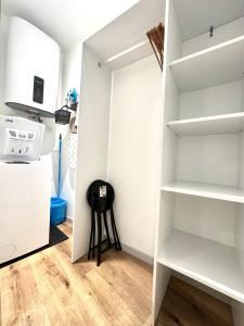 eine Küche mit weißen Regalen und einem Kühlschrank in der Unterkunft Bel appartement en plein centre ville in Limoges