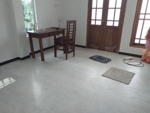 Cette chambre comprend un bureau, une chaise et une table. dans l'établissement Friendly house, à Galle