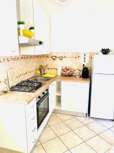 a kitchen with white cabinets and a stove top oven at Yellow House in Teramo