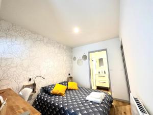 una camera da letto con un letto con cuscini gialli di Bel appartement en plein centre ville a Limoges