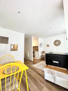 Bel appartement en plein centre ville في ليموج: غرفة معيشة مع طاولة صفراء وكراسي صفراء