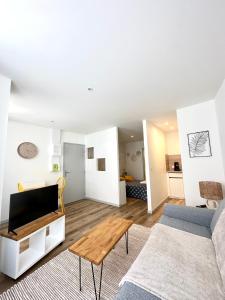 ein Wohnzimmer mit einem Sofa und einem Tisch in der Unterkunft Bel appartement en plein centre ville in Limoges