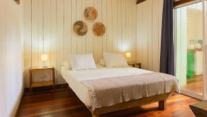 1 dormitorio con 1 cama con 2 mesas y 2 lámparas en La Rana De Cahuita, en Cahuita