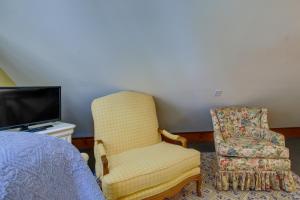 una camera con letto, sedia e TV di Romantic Cottage in Washington Historic District a Washington