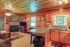 uma cozinha com paredes de madeira e uma lareira num camarote em Blue Ridge Mountain Cabin with Views and Hot Tub em Sparta