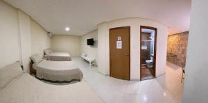 ein Krankenhauszimmer mit einem Bett und einem Bad in der Unterkunft Pousada Dubai in Itabuna