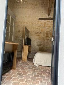 um quarto com uma cama, uma secretária e uma janela em Mini gîte royal em Sainte-Gemme-la-Plaine