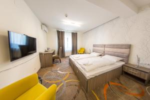 a hotel room with a bed and a television at STELLA DI MONTE in Sibiu