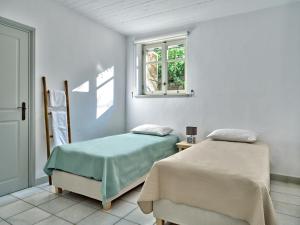 two beds in a room with a window at Myrto's House seaview of Naxos in Isterni +19 photos