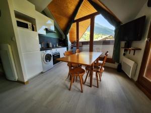 a dining room with a table and chairs in a kitchen at Appartement O'Contamines in Les Contamines-Montjoie