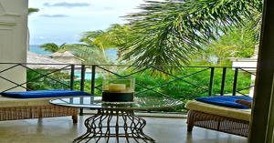 a balcony with a table and a view of the ocean at Sunny Vacation Villa No 18 in Saint Peter