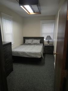 a bedroom with a bed and two windows at E. Michigan Walk Up Furnished 2 Bedroom APT in Lansing