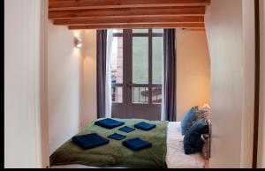 a bed with blue pillows on it with a window at Panorama apartment Briancon in Briançon