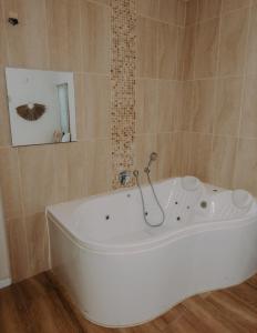 La salle de bains est pourvue d'une baignoire blanche et d'un miroir. dans l'établissement Hippie house בית היפי, à Mitzpe Ramon