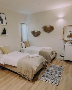 - une chambre avec 2 lits et un miroir mural dans l'établissement Hippie house בית היפי, à Mitzpe Ramon