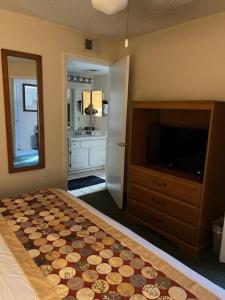 a bedroom with a bed and a dresser and a television at #1BR Condo 15Mins To Disney, Universal, Old Town & Parks in Kissimmee