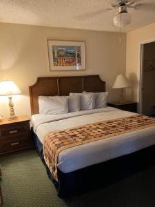 a hotel room with a large bed and two lamps at #1BR Condo 15Mins To Disney, Universal, Old Town & Parks in Kissimmee