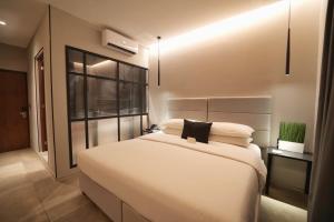 a bedroom with a large white bed and a window at Ontico Urban Design Hotel in Mérida