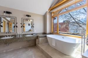 a large bathroom with two sinks and a large tub at Brewster Mountain Lodge in Banff +33 photos