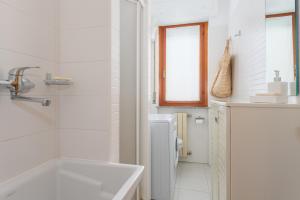 Casa Grazia في أوريستانو: حمام أبيض مع حوض ومغسلة