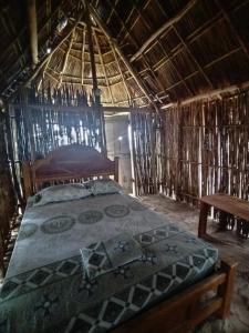 a bedroom with a bed in a straw hut at Gunayar amazing in Arritupo Número Dos