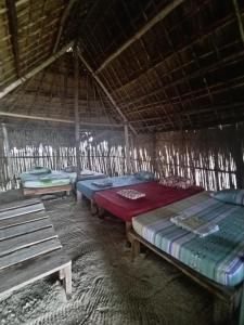 a room with three beds in a straw hut at Gunayar amazing in Arritupo Número Dos