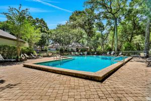 a swimming pool in a yard with chairs and trees at Lucky Enough in Fernandina Beach