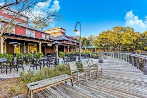 a wooden boardwalk with chairs and tables in front of a restaurant at Lucky Enough in Fernandina Beach