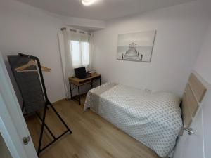 een slaapkamer met een bed en een bureau met een laptop bij Antonio Apartments in Alicante