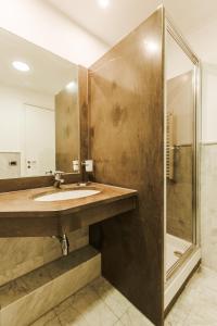 uma casa de banho com um lavatório e um chuveiro em Hotel Carpi em Carpi