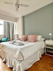 a bedroom with a large white bed with pink pillows at Great Apartment in Recoleta in Buenos Aires