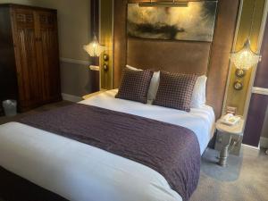 1 dormitorio con 1 cama grande en una habitación en Saracens Head Hotel by Greene King Inns, en Towcester