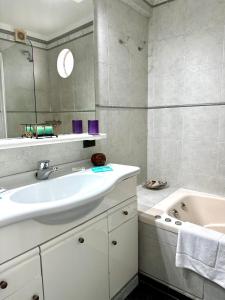 a white bathroom with a sink and a tub at Great Apartment in Recoleta in Buenos Aires