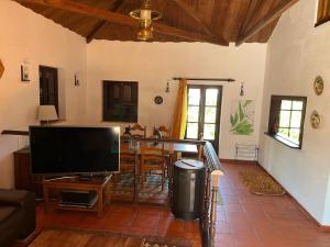 sala de estar con TV y mesa en A place in the sun, en Longueira