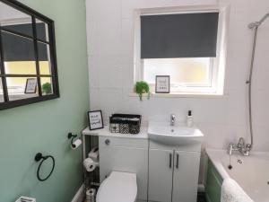 a bathroom with a sink and a toilet and a window at Afan House in Port Talbot +15 photos