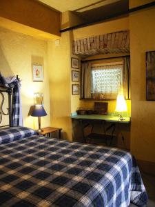 a bedroom with a bed and a desk and a window at La Traversina in Stazzano