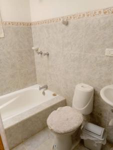 a bathroom with a toilet and a tub and a sink at Finca Hotel Nutabes in San Pedro