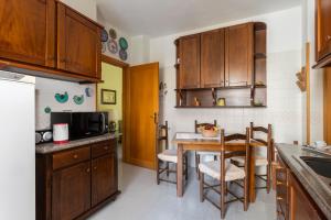 a kitchen with wooden cabinets and a table with chairs at Casa Grazia in Oristano