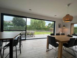 een woonkamer met een tafel en stoelen en een groot raam bij Boldermountain Guesthouse in Heusden - Zolder